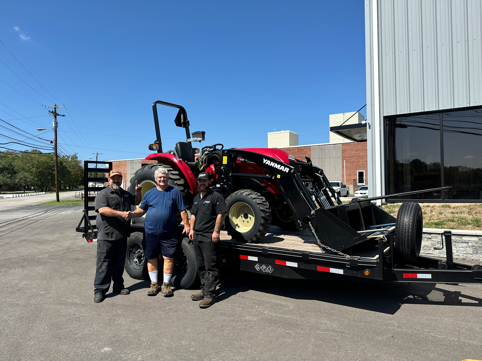 Tractor House equipment staff infront of Yanmar on trailer